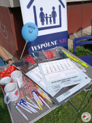 Zdjęcie przedstawia artykuły promocyjne: kubki, kalendarze, smycze, breloczki, długopisy, opaski odblaskowe dotyczące przeciwdziałaniu przemocy domowej