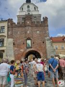 Seniorzy wychodzą po schodach w tle zabytkowa kamienica