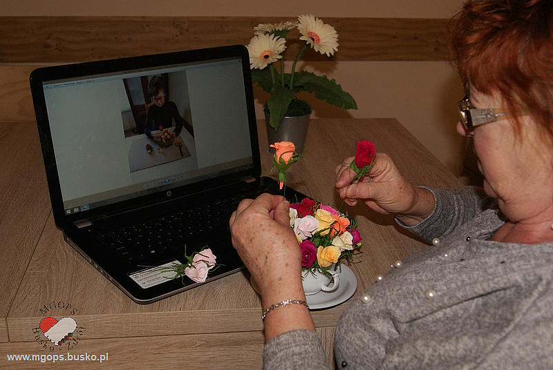 Seniorka układa bukiet różyczek w filiżance